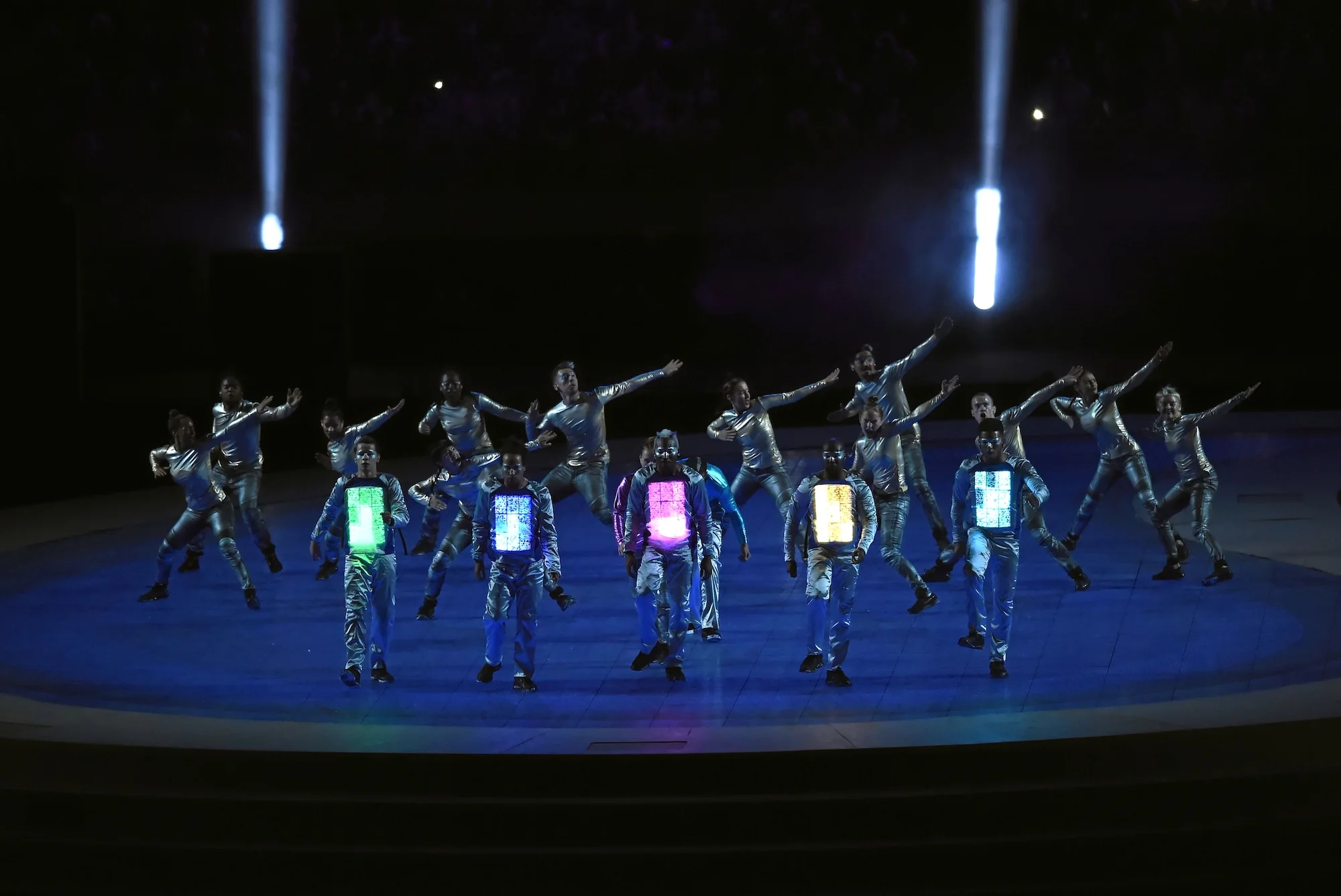 Dancers performing on stage in illuminated LED costumes